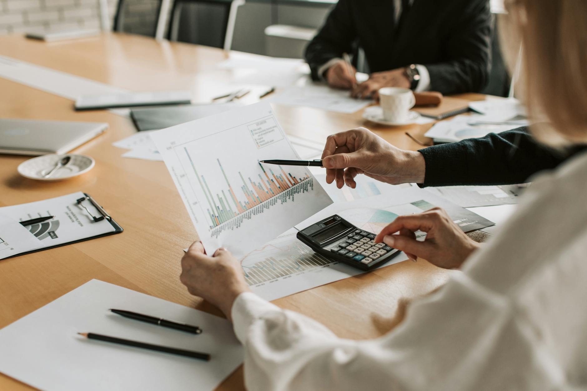 Group of people looking at a graph at a table together. Photo by Vlada Karpovich on Pexels.com
